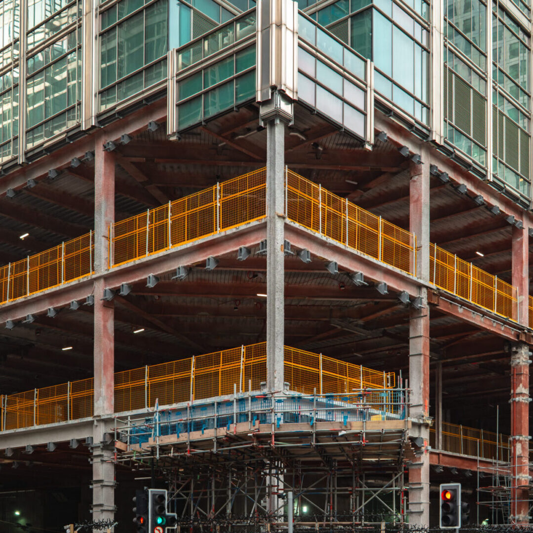 Building under construction with scaffolding and barriers.